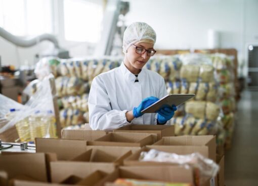 "Food science and technology: Female worker using tablet for quality control in a food factory.