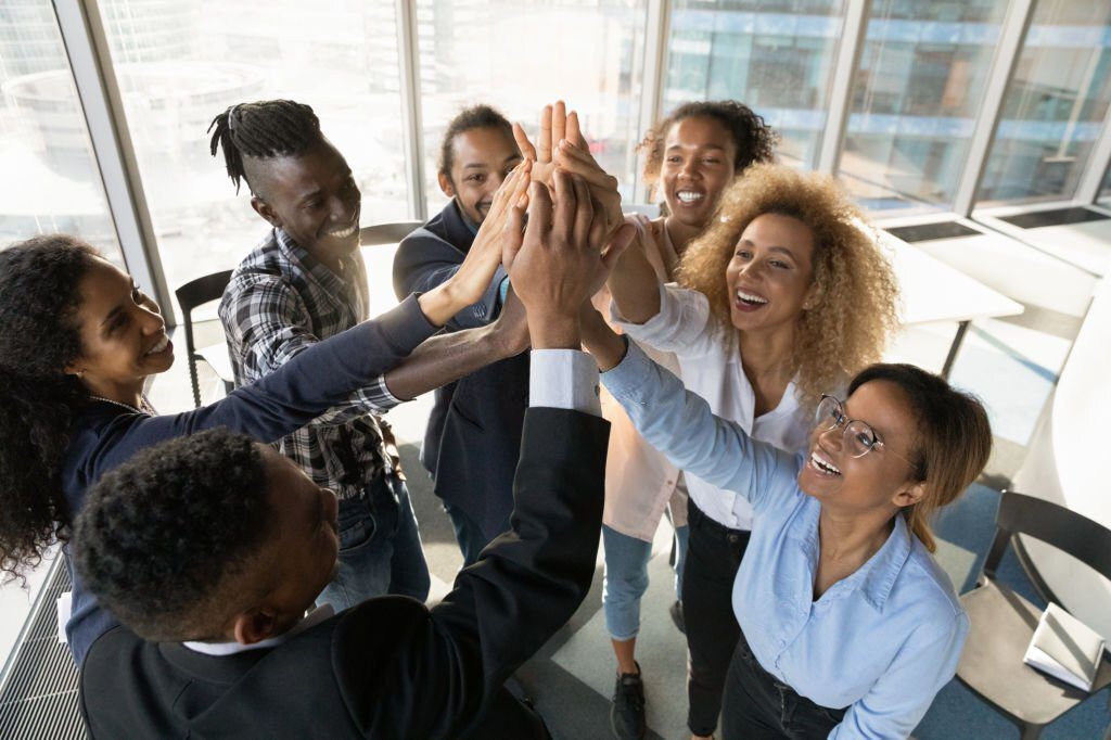 This an image of 7 workers joining their hands after successful networking