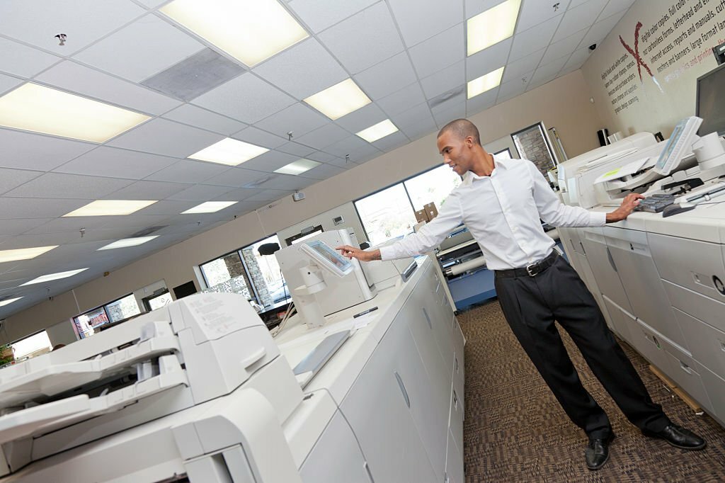 This is an image of an archives administrator in an printing room keying instructions to a printer